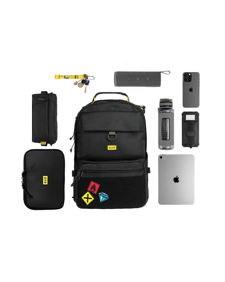 Black backpack with various items on a white background